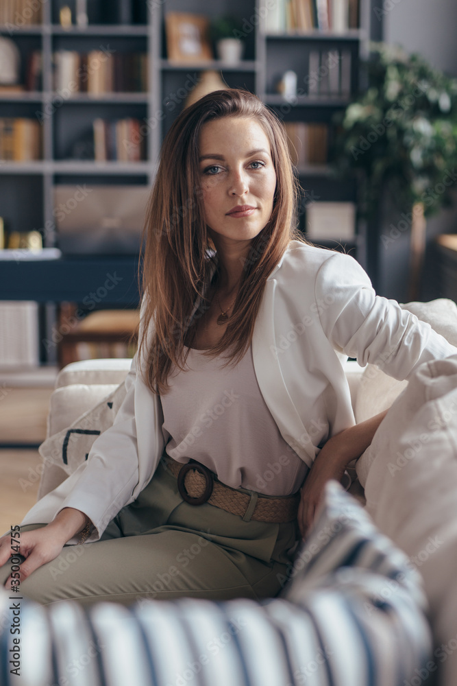 Woman sitting on sofa and looking at camera. Woman sitting on sofa and looking at camera.