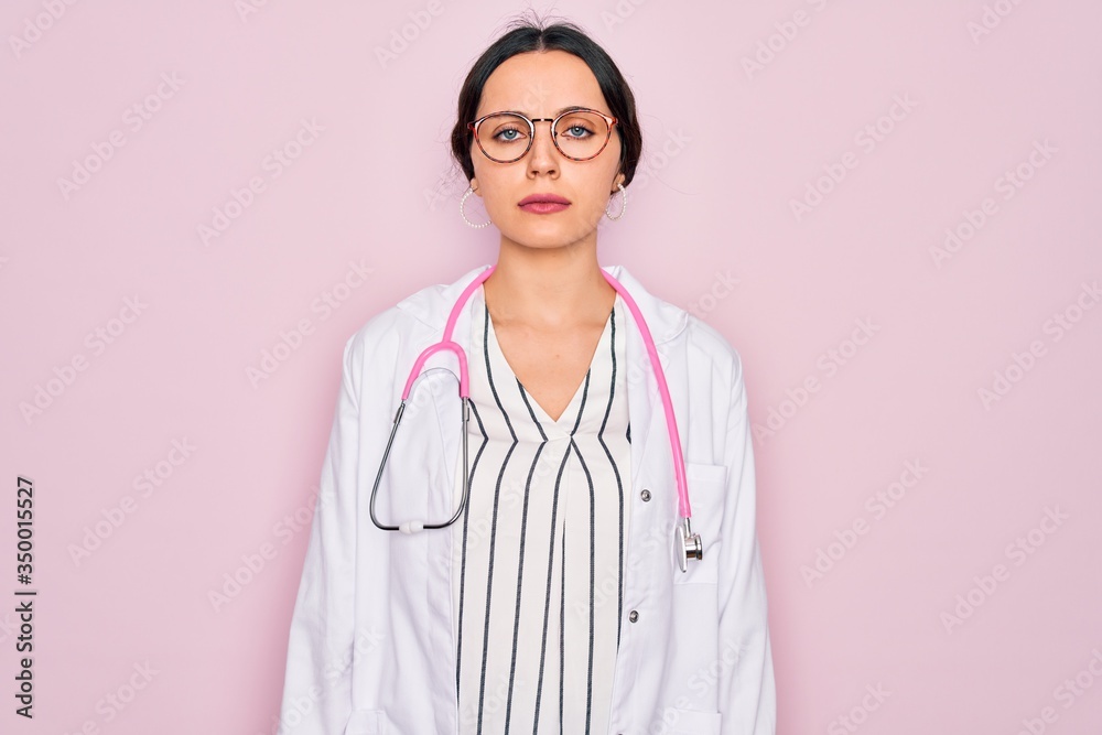 Beautiful doctor woman with blue eyes wearing coat and stethoscope over pink background skeptic and nervous, frowning upset because of problem. Negative person. Beautiful doctor woman with blue eyes wearing coat and stethoscope over pink background skeptic and nervous, frowning upset because of problem. Negative person.