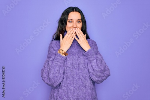фотографія Young beautiful woman wearing casual turtleneck sweater standing over purple bac