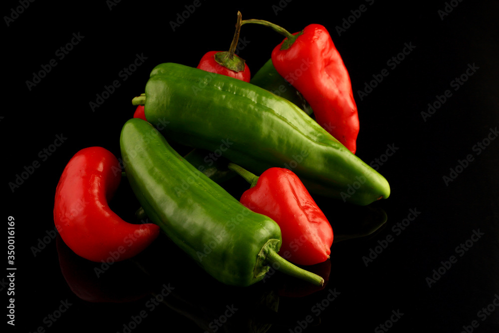 red and green chili peppers on black background. 