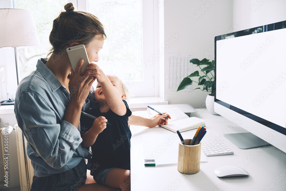Mother working from home with little child. - obrazy, fototapety, plakaty 