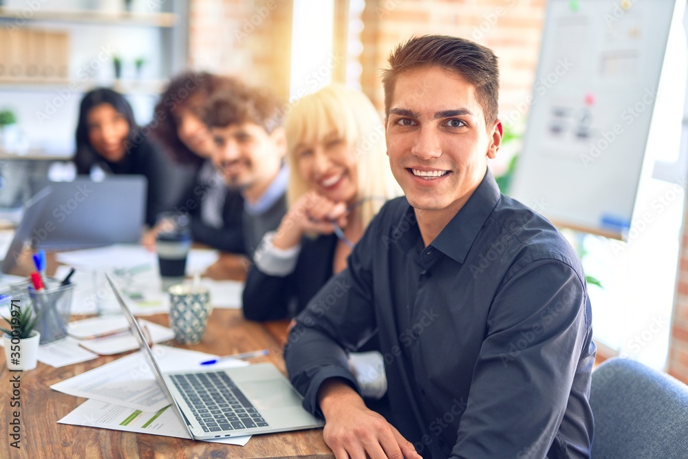 Group of business workers sitting in line with smile on face. Looking at the camera, young man smiling at the office Group of business workers sitting in line with smile on face. Looking at the camera, young man smiling at the office