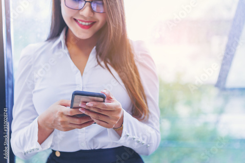 Crop image of Young smiling business woman using smartphone. selected focus