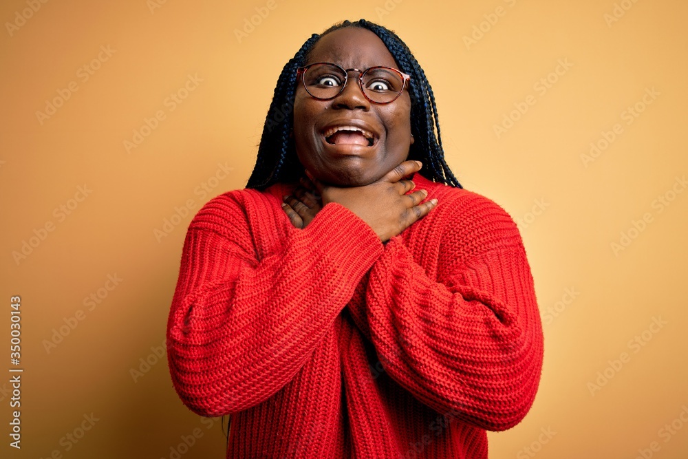 African american plus size woman with braids wearing casual sweater over yellow background shouting and suffocate because painful strangle. Health problem. Asphyxiate and suicide concept. African american plus size woman with braids wearing casual sweater over yellow background shouting and suffocate because painful strangle. Health problem. Asphyxiate and suicide concept.