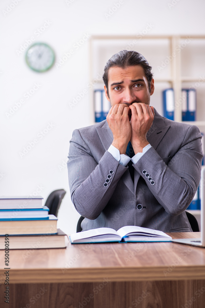 Young male businessman reading books at workplace Young male businessman reading books at workplace