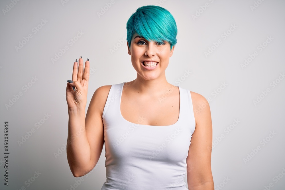 Young beautiful woman with blue fashion hair wearing casual t-shirt over white background showing and pointing up with fingers number three while smiling confident and happy. Young beautiful woman with blue fashion hair wearing casual t-shirt over white background showing and pointing up with fingers number three while smiling confident and happy.