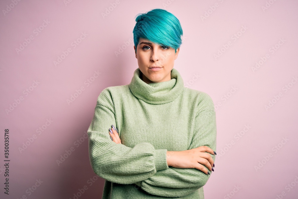 Young beautiful woman with blue fashion hair wearing casual turtleneck sweater skeptic and nervous, disapproving expression on face with crossed arms. Negative person. Young beautiful woman with blue fashion hair wearing casual turtleneck sweater skeptic and nervous, disapproving expression on face with crossed arms. Negative person.