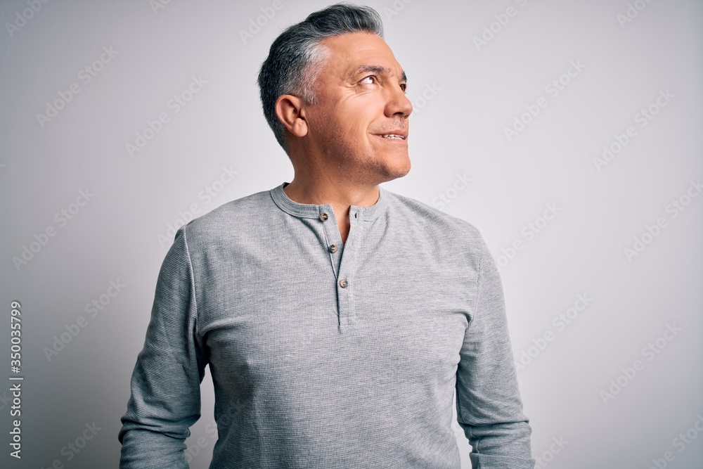 Middle age handsome grey-haired man wearing casual t-shirt over white background looking away to side with smile on face, natural expression. Laughing confident. Middle age handsome grey-haired man wearing casual t-shirt over white background looking away to side with smile on face, natural expression. Laughing confident.