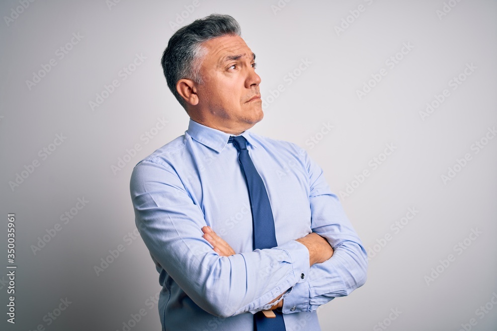 Middle age handsome grey-haired business man wearing elegant shirt and tie looking to the side with arms crossed convinced and confident Middle age handsome grey-haired business man wearing elegant shirt and tie looking to the side with arms crossed convinced and confident