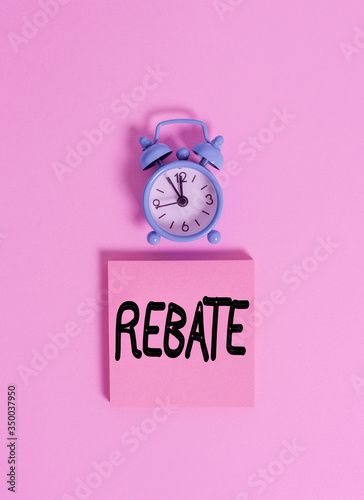 Handwriting text writing Rebate. Conceptual photo Huge rewards that can get when you engaged to a special promo Vintage alarm clock wakeup blank notepad sticky note colored background photo