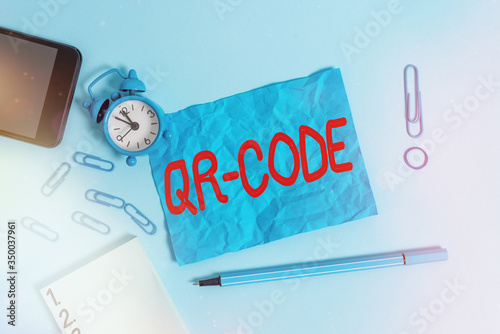 Conceptual hand writing showing Qr Code. Concept meaning the trademark for a type of matrix barcode A machinereadable code Alarm clock notepad smartphone band marker colored background photo