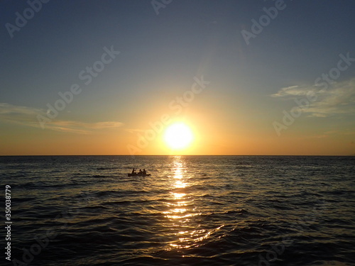 ボルネオの夕日の海を走るボート
