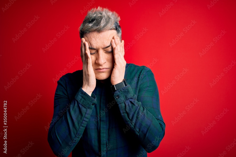 Young handsome modern man wearing elegant green shirt over red isolated background with hand on headache because stress. Suffering migraine. Young handsome modern man wearing elegant green shirt over red isolated background with hand on headache because stress. Suffering migraine.