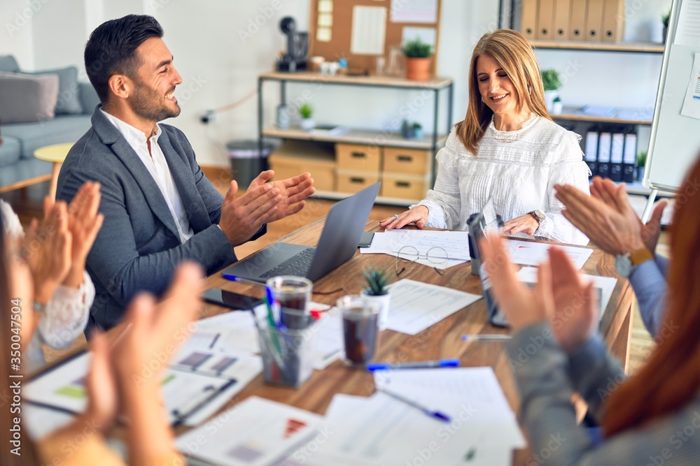 Group of business workers smiling happy and confident. Working together with smile on face applauding one of them at the office Group of business workers smiling happy and confident. Working together with smile on face applauding one of them at the office