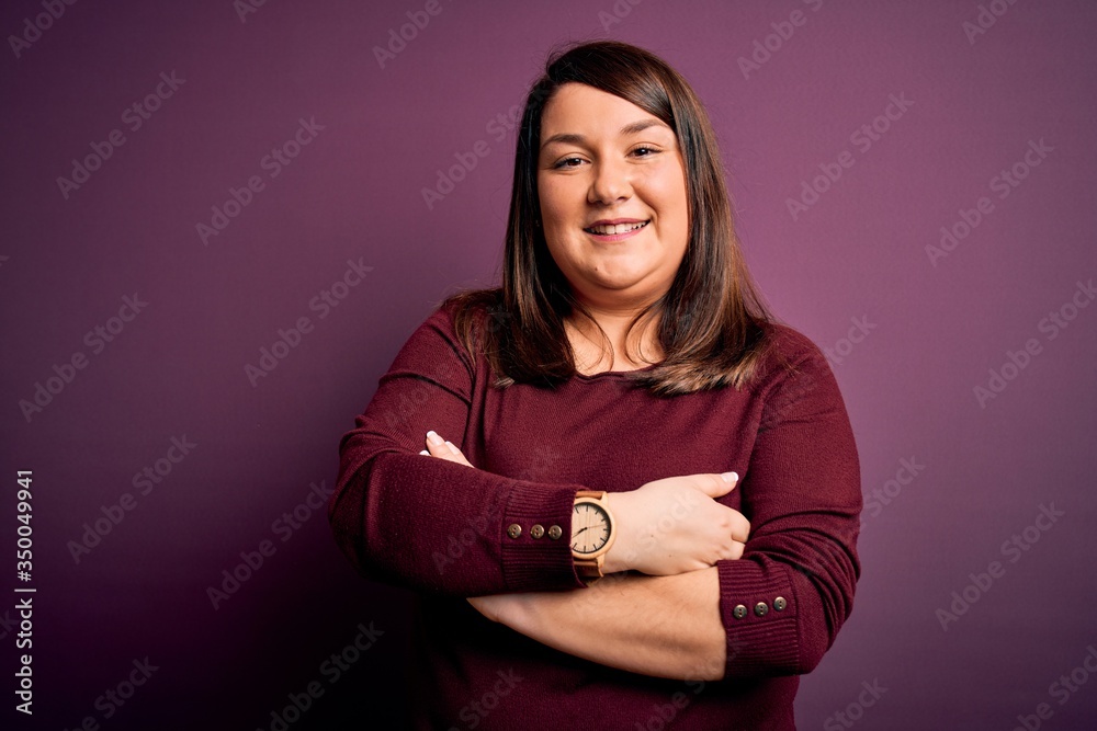 Obraz premium Beautiful brunette plus size woman wearing casual sweater over isolated purple background happy face smiling with crossed arms looking at the camera. Positive person.