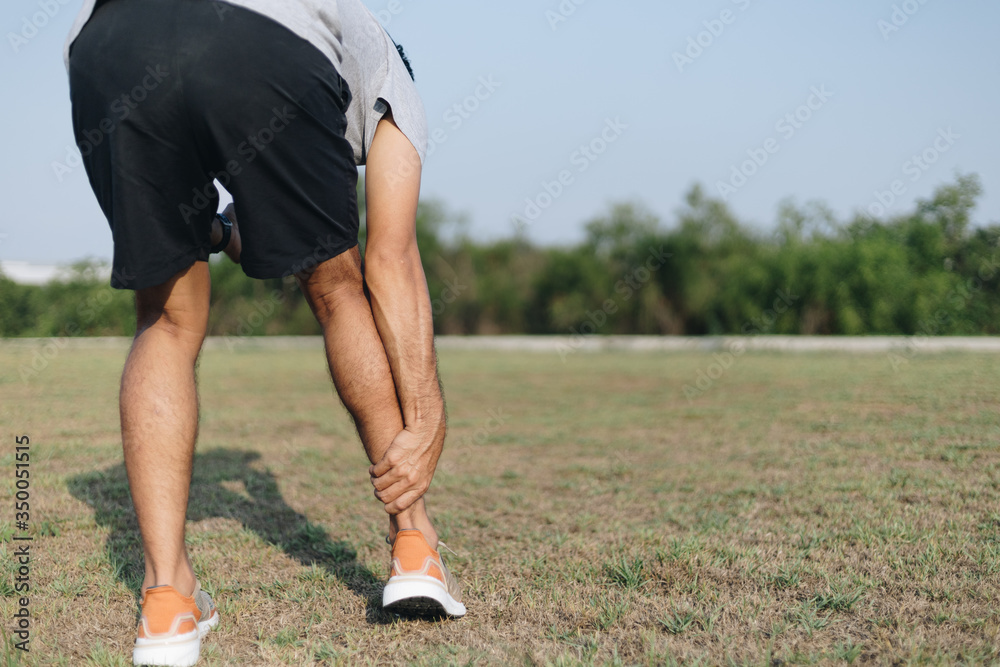 Fototapeta premium Sports man holding pain in the calf, after running and exercise