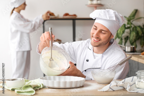 Smiling male chef pouring b...