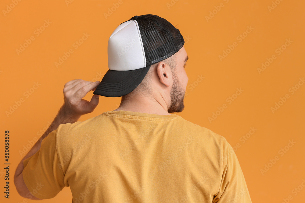 Handsome man in stylish cap on color background Handsome man in stylish cap on color background