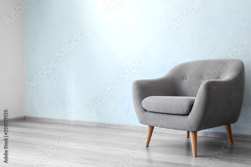 Comfortable armchair near light wall in room