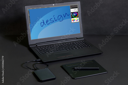 Pen tablet, with a laptop and a hard drive on a black background