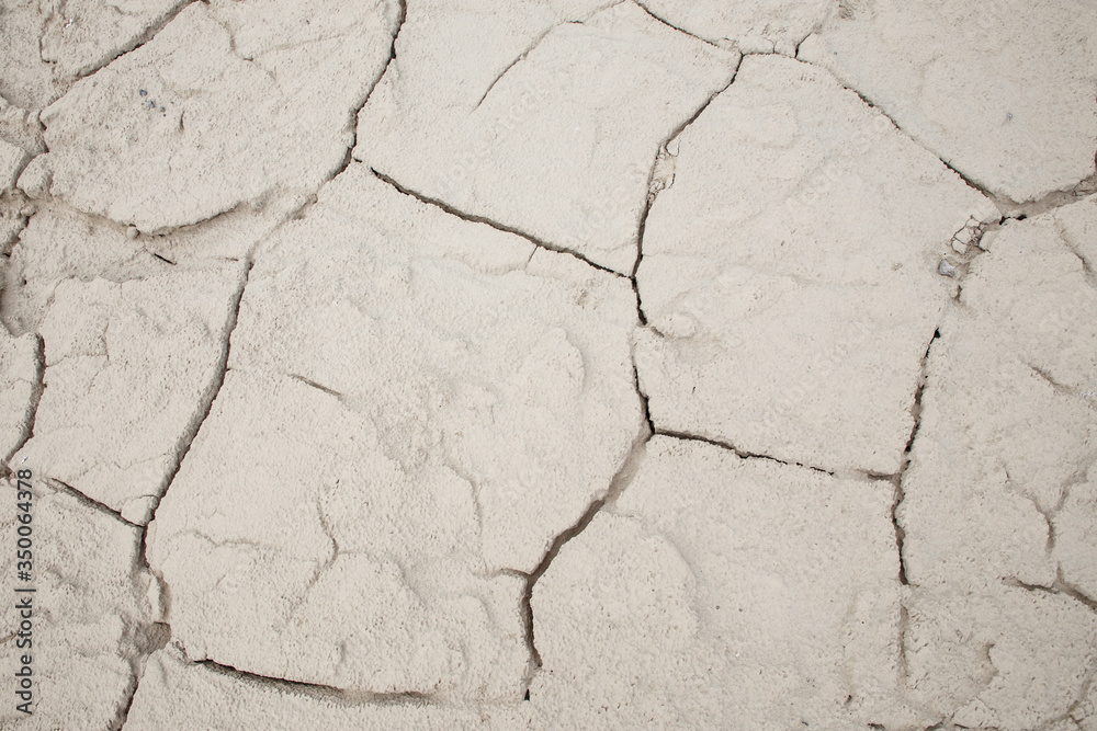 Obraz premium Cracked earth soil ground texture background. Mosaic pattern of dried mud clay earth and sand, top view. The concept of soil erosion climate change and sudden changes in air temperature.
