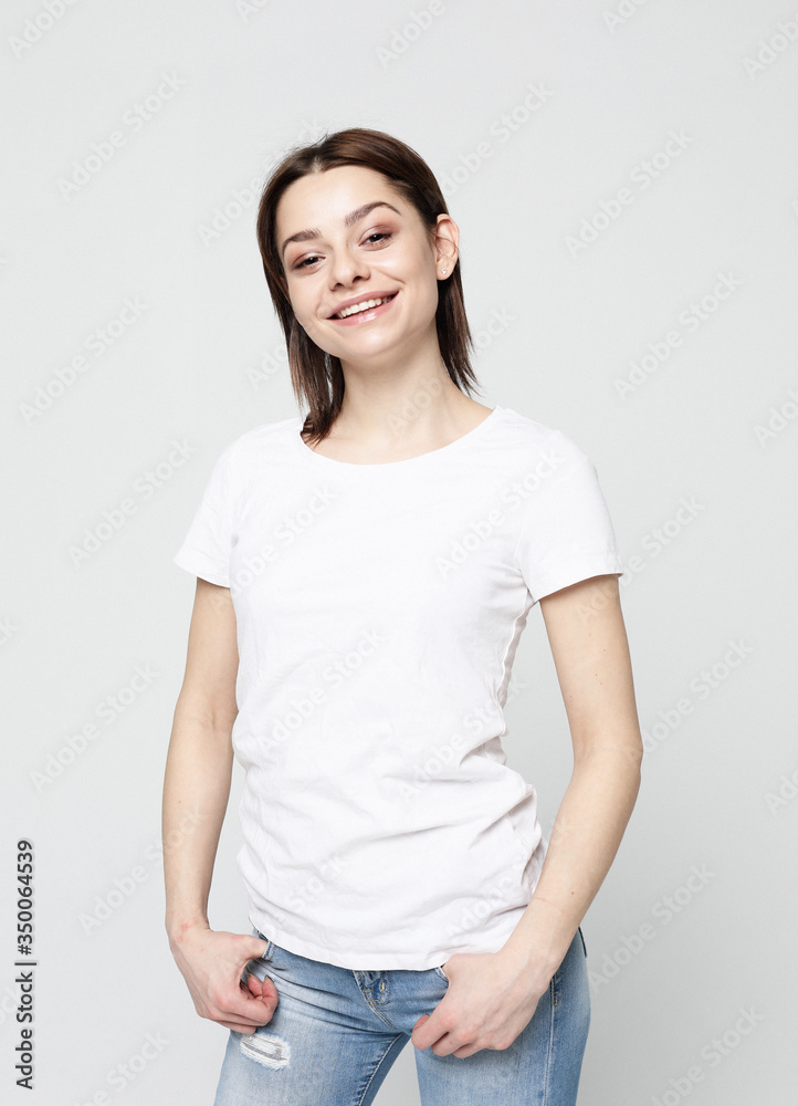 Portrait of young positive female with cheerful expression, dressed in casual clothes