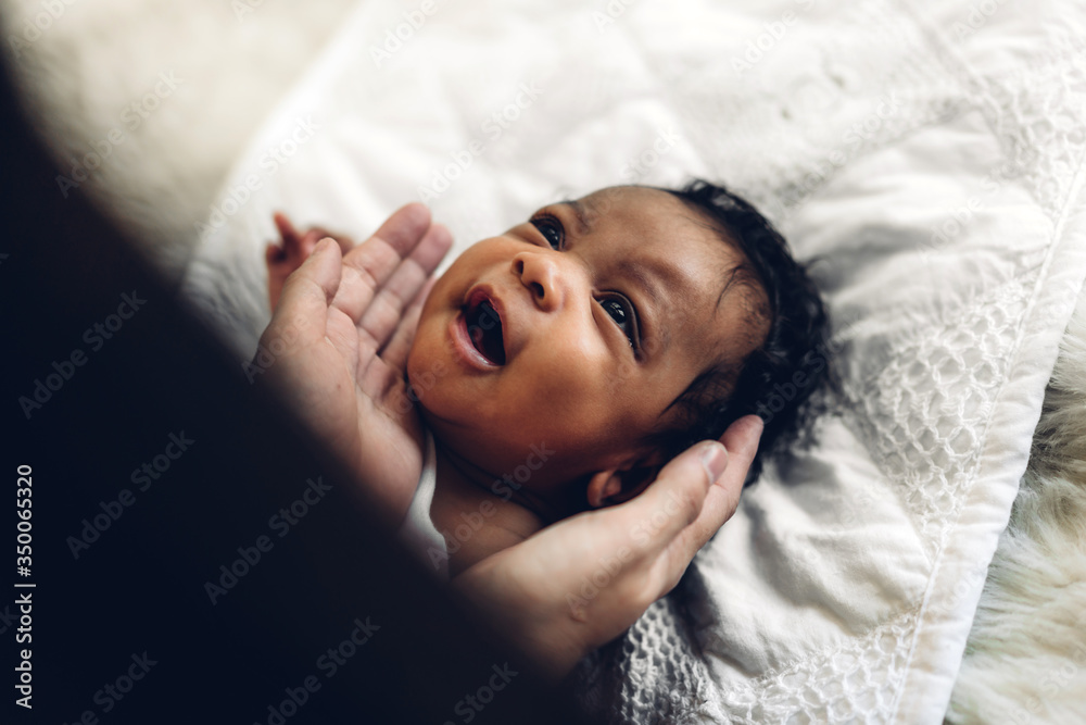 Fototapeta premium Portrait of enjoy happy love family african american mother playing with adorable little african american baby.Mom touching with cute son moments good time in a white bedroom.Love of black family