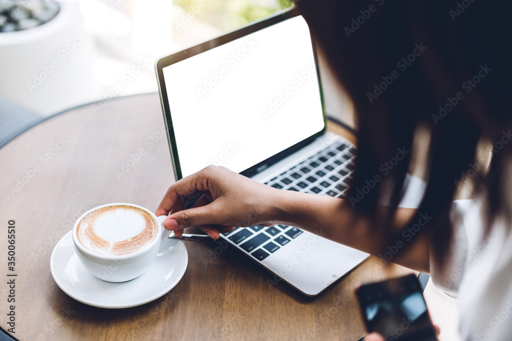 Woman relaxing using technology of laptop computer with white mockup blank screens while sitting on chair drink coffee in cafe and restaurant.Communication and technology concept Woman relaxing using technology of laptop computer with white mockup blank screens while sitting on chair drink coffee in cafe and restaurant.Communication and technology concept