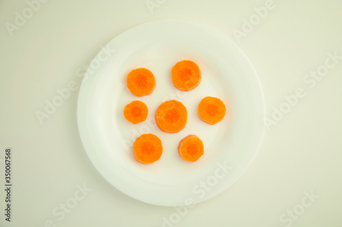 sliced fresh carrots in circles on a white background