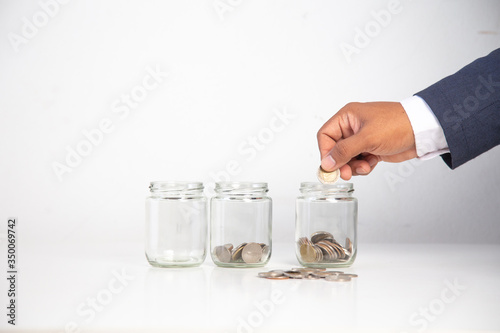 business man hand holding a coin in a glass bottle,.Concept: saving  coin family money for home dreams,.symbol growing  investment success wealth to  benefit,.business growth  banking for  cash