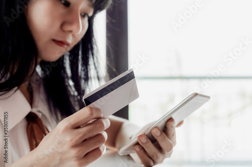 Asian woman holding a credi...