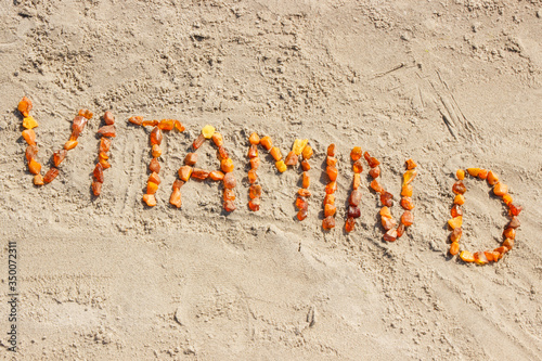 Inscription vitamin D on sand at beach, summer time and healthy lifestyle
