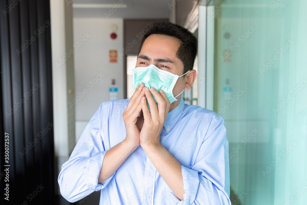 A asian man wearing mask a face prevent the spread of the Covid-19 virus while coughing, sneezing in workplace. A asian man wearing mask a face prevent the spread of the Covid-19 virus while coughing, sneezing in workplace.