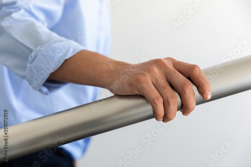 Tableau sur toile Hand holding banisters, The germ spread from person to person through direct phy