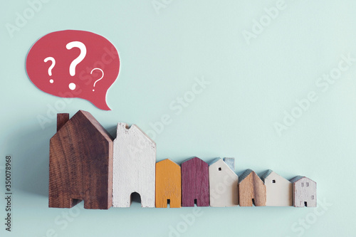 Photos Wooden houses with question marks, housing crisis, confused decision, insecure i