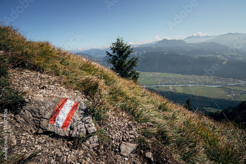 Trail marker in the Austrian alps with the Inntal valley visible in the distance