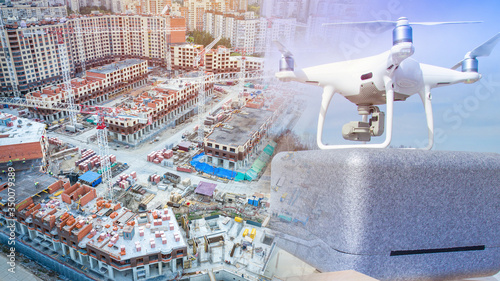 Drone on the background of multi-storey buildings under construction. Modern construction control technologies. Using a drone to explore hard-to-reach areas of the building. Unmanned aerial vehicle.