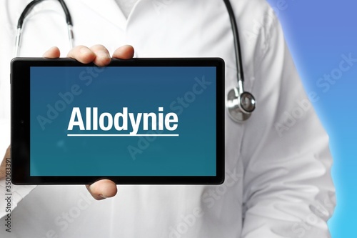 Allodynie. Arzt mit Stethoskop hält Tablet-Computer in Hand. Text im Display. Blauer Hintergrund. Krankheit, Gesundheit, Medizin photo