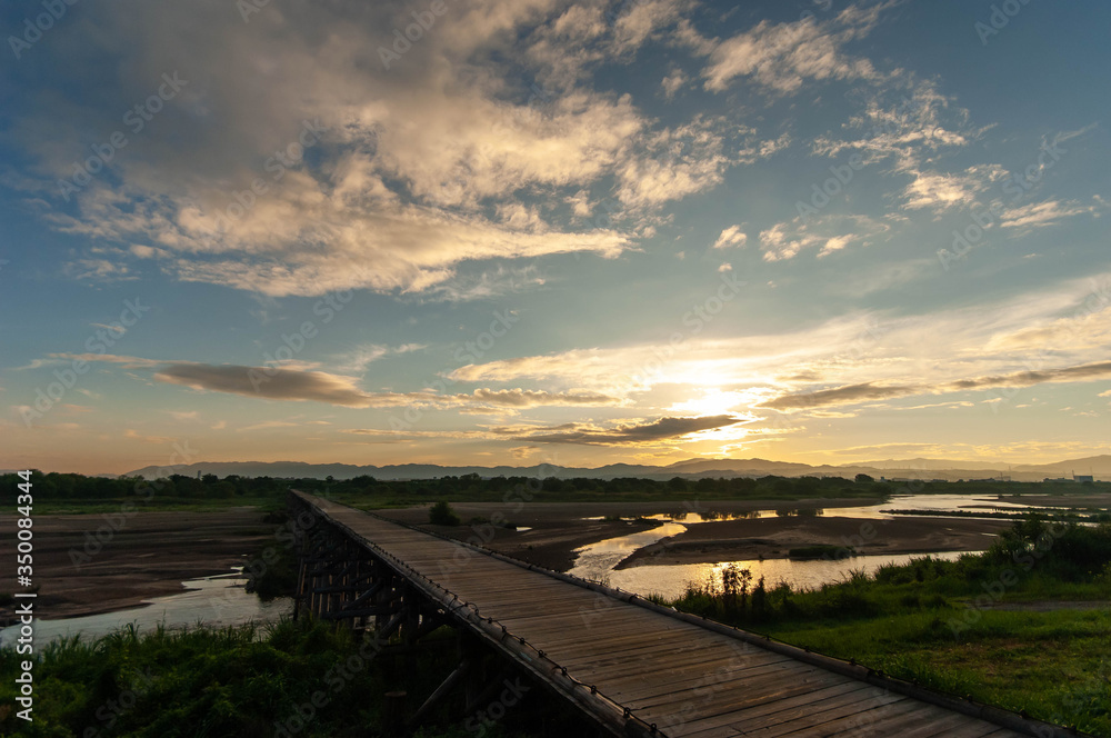 京都の川に架かる木製の橋と朝日