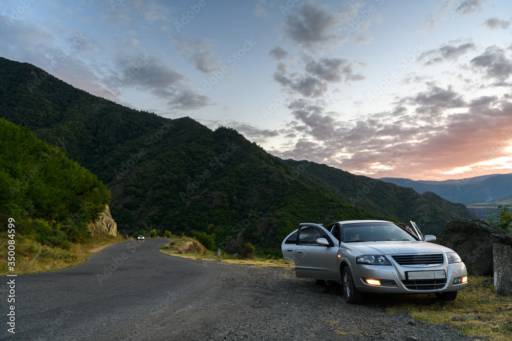 Silver car on the mountain road on the sunset. Alaverdi, Armenia