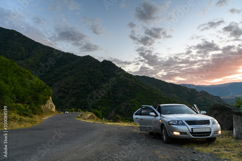 Silver car on the mountain road on the sunset. Alaverdi, Armenia