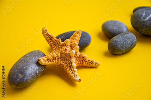 Nautical, Marrine concept. Starfish with Stones against a Yellow background with copy Space photo