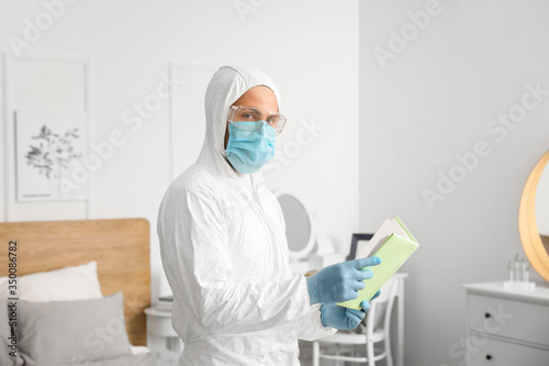 Man in biohazard suit readi...