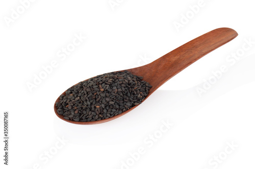 Black sesame seeds in wood spoon isolated on white background
