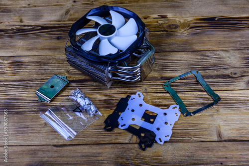 Modern cpu cooler with heat pipes and installation kit on a wooden background photo