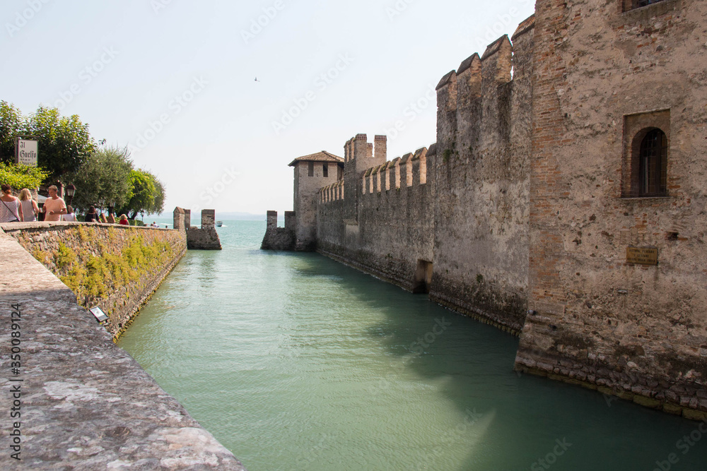 The view ancient walls and moat of Scaliger Castle, Sirmione, Lombardy, Italy. The view ancient walls and moat of Scaliger Castle, Sirmione, Lombardy, Italy.