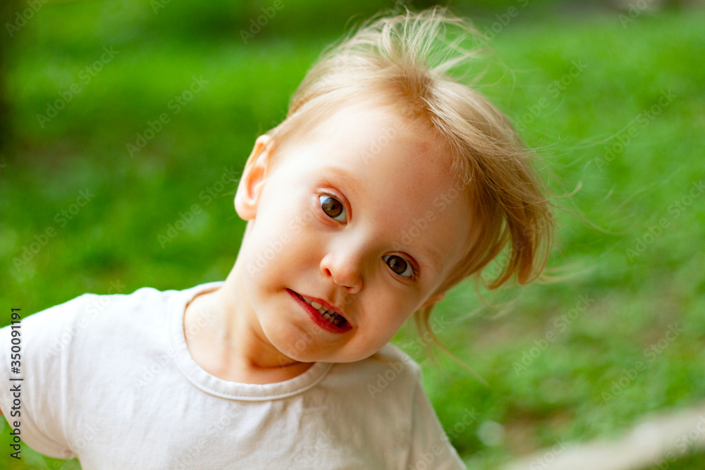 Portrait of cute blond toddler girl in a windy summer day making faces and showing white teeth. Portrait of cute blond toddler girl in a windy summer day making faces and showing white teeth.
