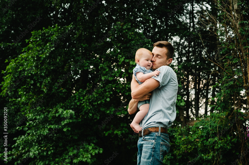 Portrait dad with child together. Daddy hugging little daughter outdoors. Young father with baby girl walk in park. Family holiday in garden or forest. Father hug baby in nature. Portrait dad with child together. Daddy hugging little daughter outdoors. Young father with baby girl walk in park. Family holiday in garden or forest. Father hug baby in nature.