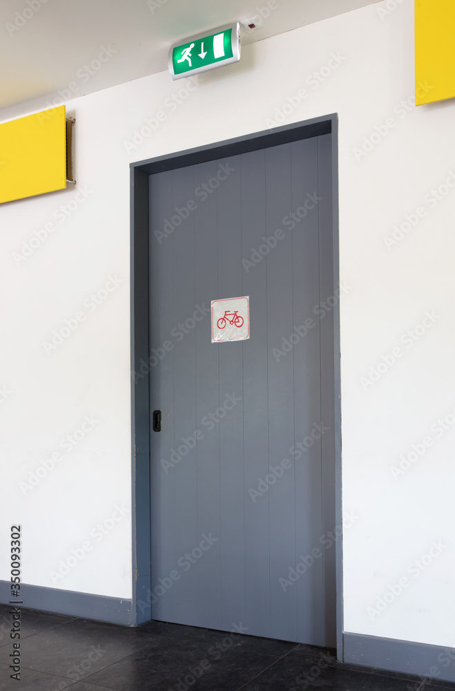 Emergency exit wooden door with tablet above it Emergency exit wooden door with tablet above it