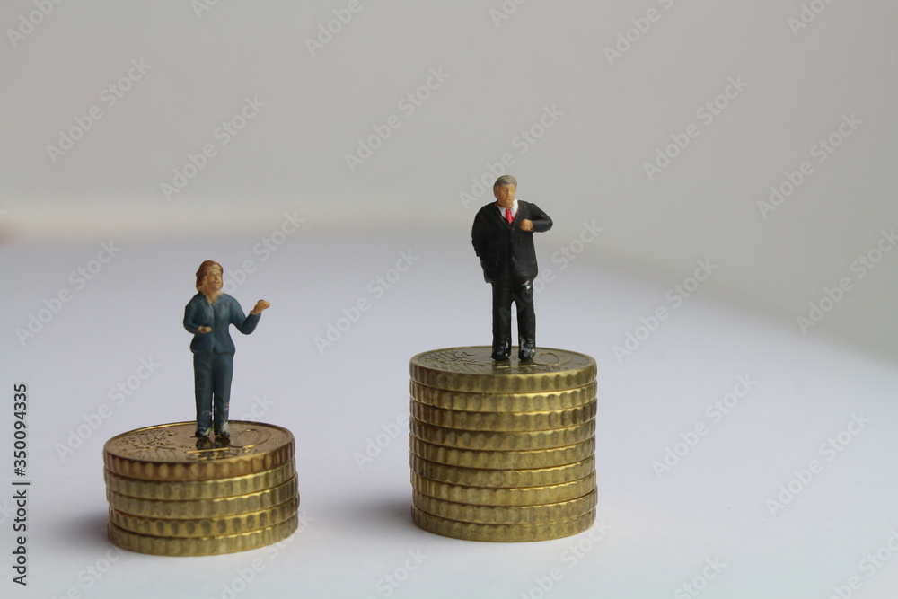 kleine Figuren auf unterschiedlich hohen Münzstapeln stehen für die ungleiche Bezahlung von Frauen und Männern kleine Figuren auf unterschiedlich hohen Münzstapeln stehen für die ungleiche Bezahlung von Frauen und Männern